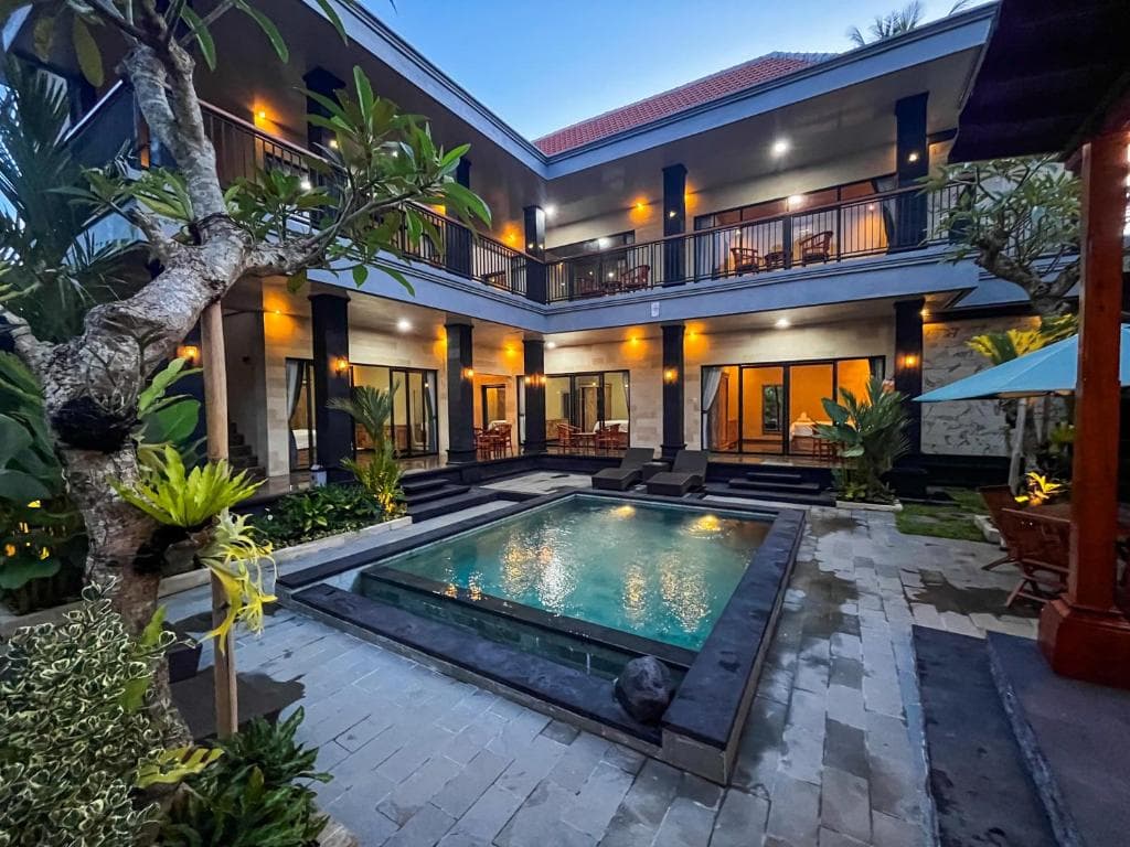 Courtyard with the pool and the two floors of rooms at dusk