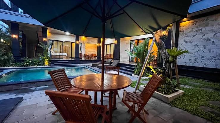 Wooden table under a parasol by the pool