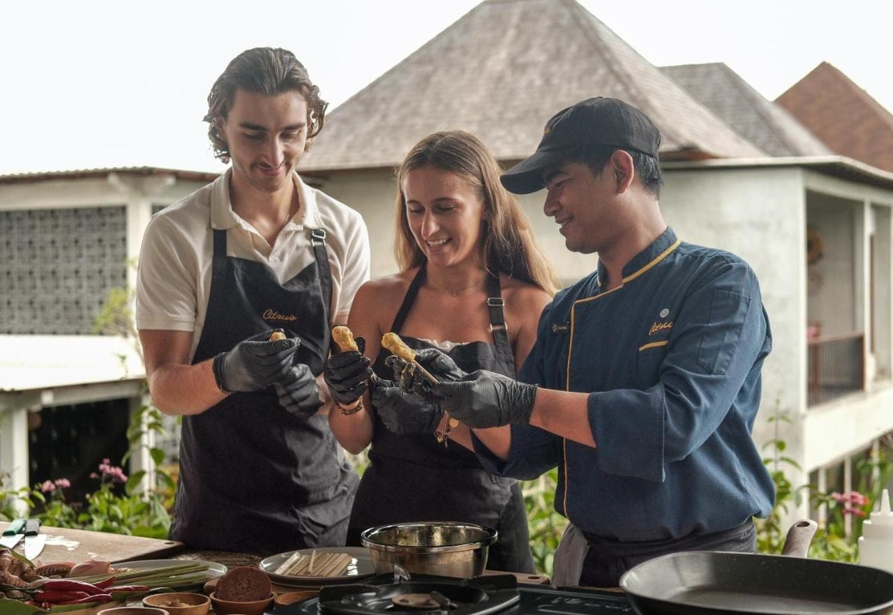 a group of three people preparing food on a grill at Emana Akatara in Ubud