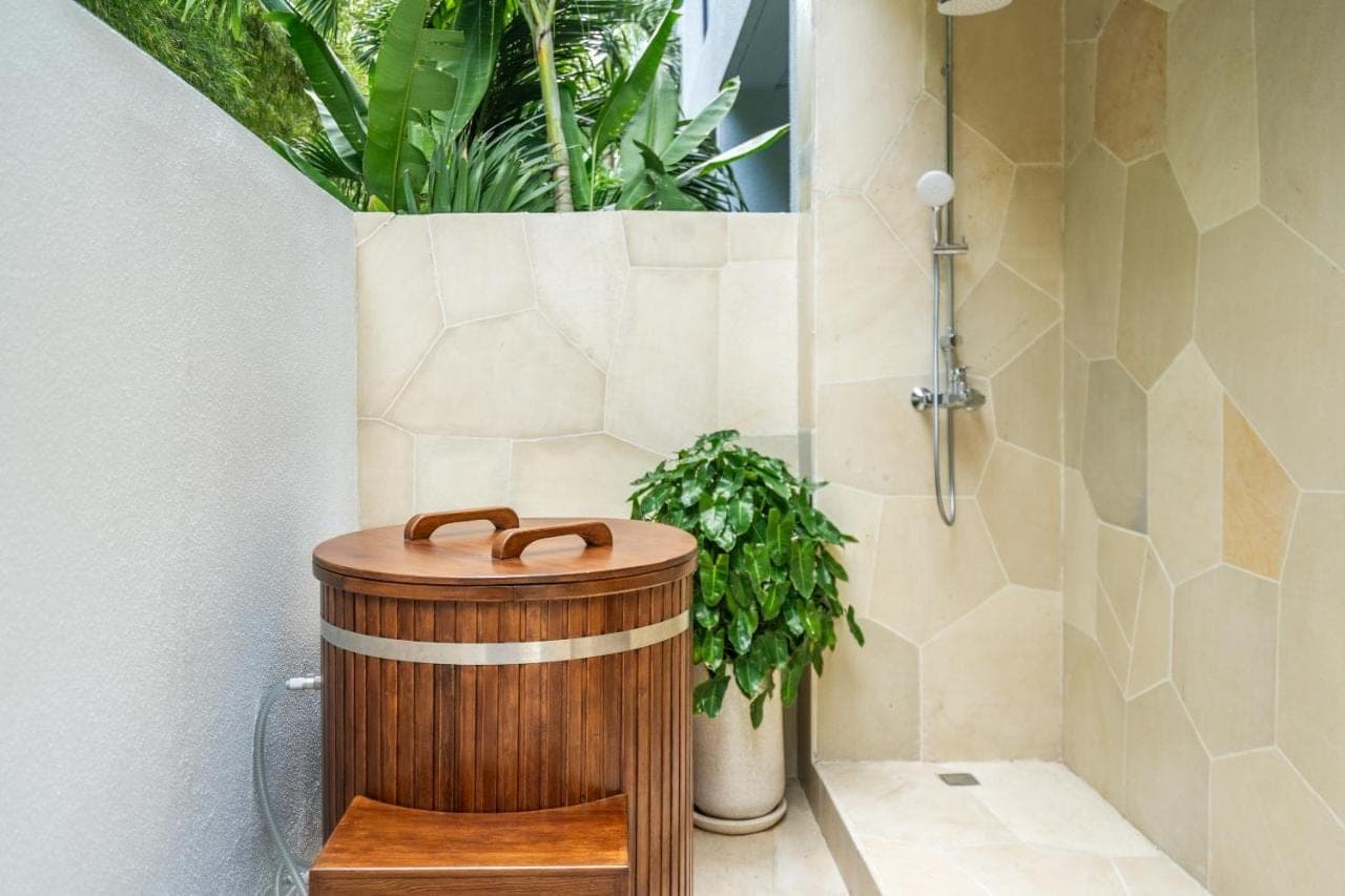 a shower with a wooden barrel in a bathroom at Sunny Muse by Betterplace in Canggu