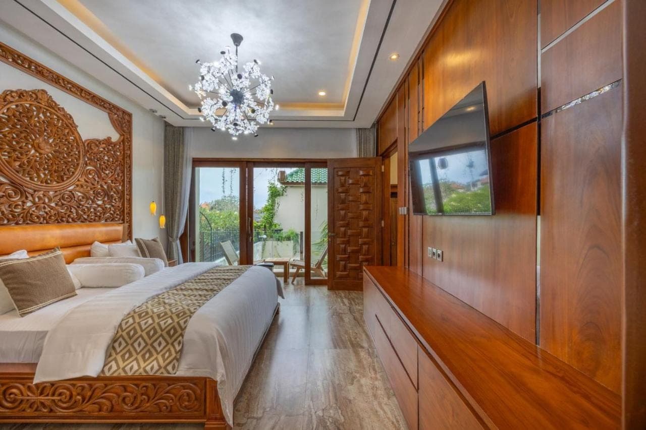 a bedroom with a large bed and a television at MJ Villa Sanur in Sanur