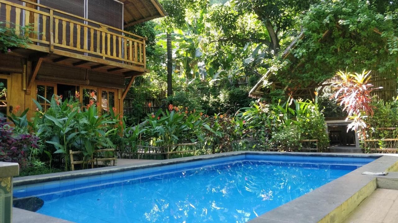 a swimming pool in front of a house at Villa Kong in Amed