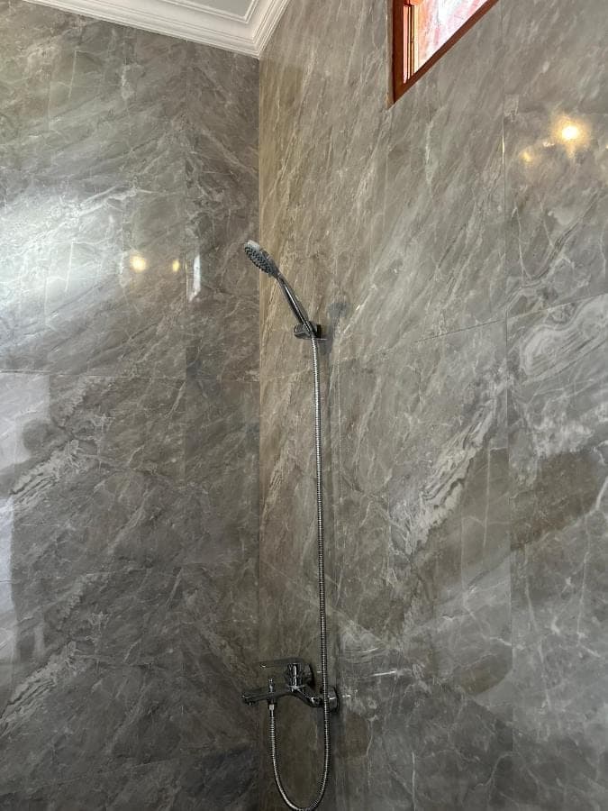 a shower with a glass door in a bathroom at Merta House Sidemen in Sidemen