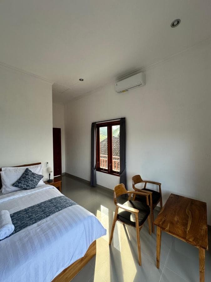 a bedroom with a bed and a table and a chair at Merta House Sidemen in Sidemen