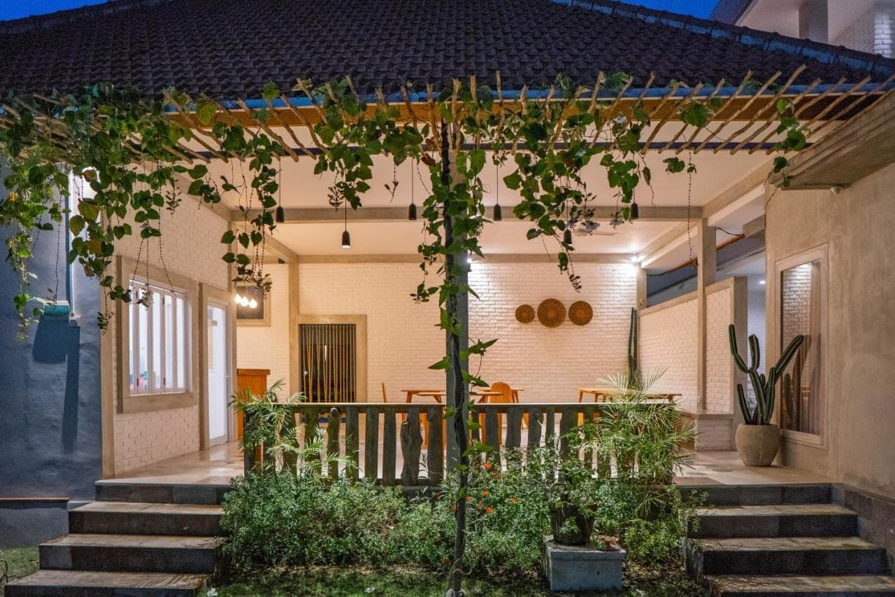 a home with a porch with stairs and plants at Berawa Dini Guesthouse in Canggu
