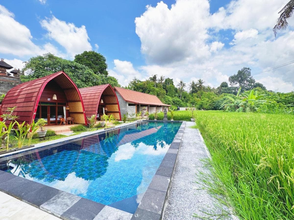 an image of a swimming pool in front of a house at Uma Raos Cottage in Ubud
