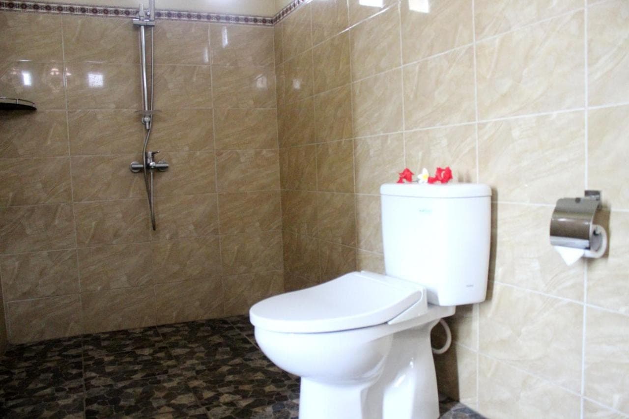 a bathroom with a toilet and a shower at Maha Neka Villa in Sidemen