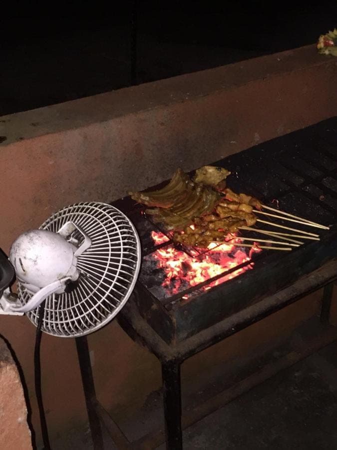 a bird sitting on a fan next to a grill at Maha Neka Villa in Sidemen