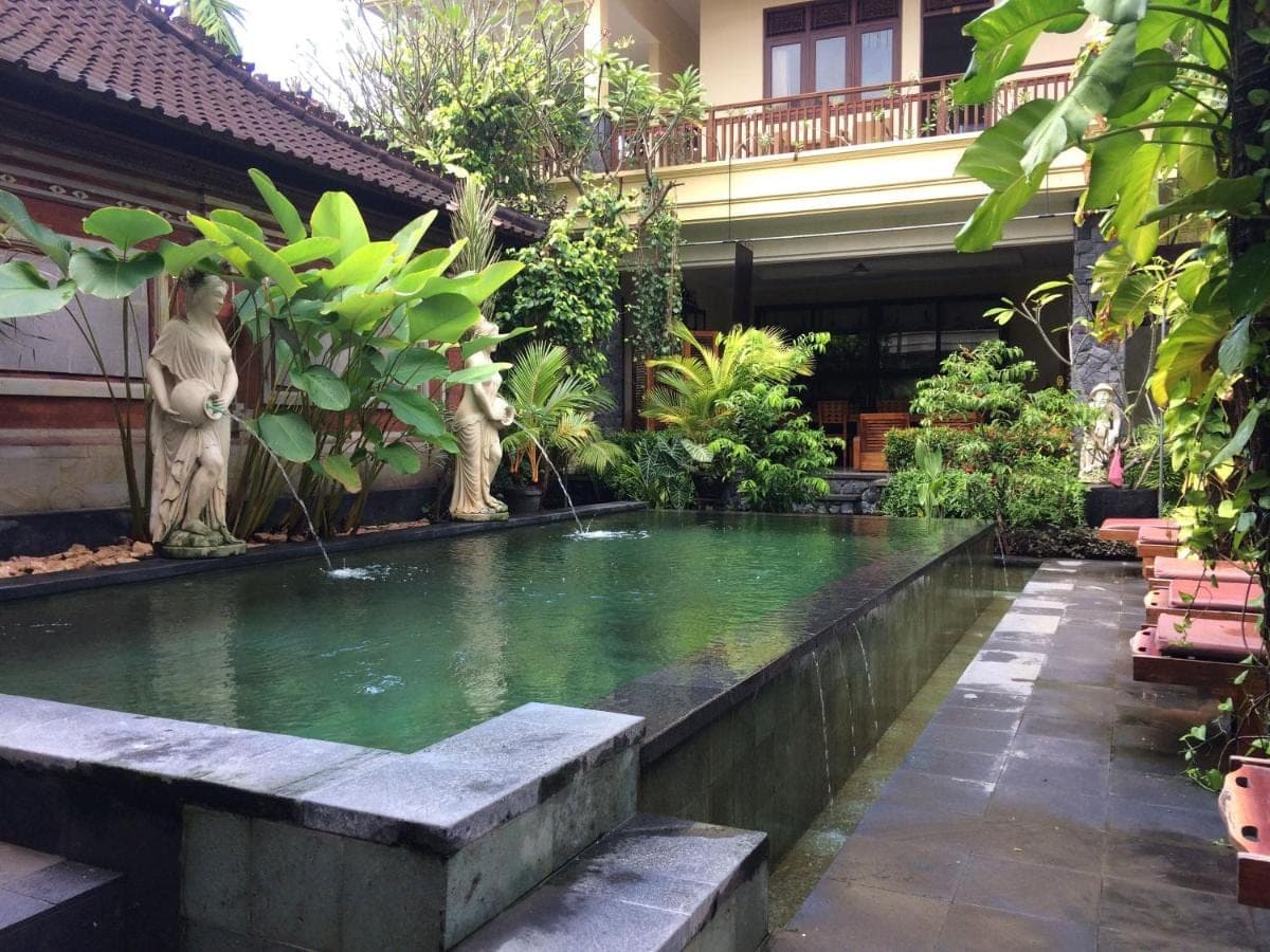 a pond in the middle of a garden at Yulia 1 in Sanur