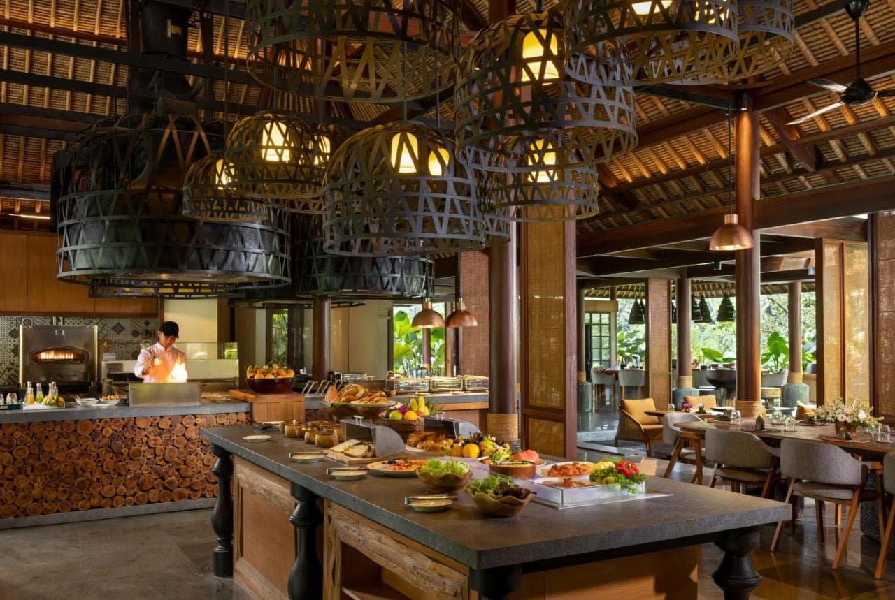 a restaurant with a buffet with food on a table at Impiana Private Villas Ubud in Ubud