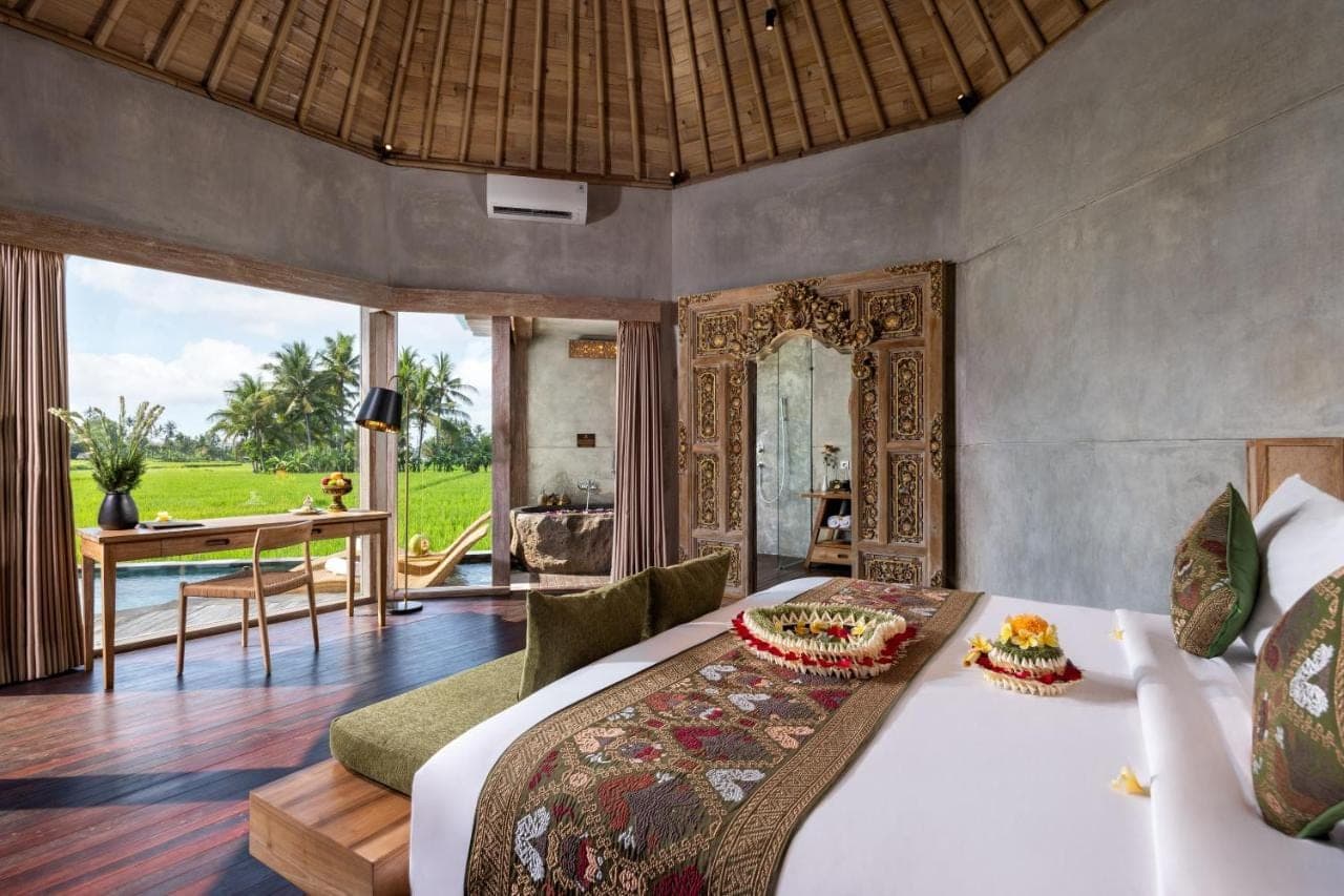 a bedroom with a bed and a desk in a room at thewakanda Resort A Pramana Experience in Ubud