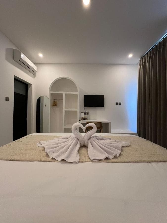 a bedroom with a bed with white towels on it at Casadela Canggu in Canggu