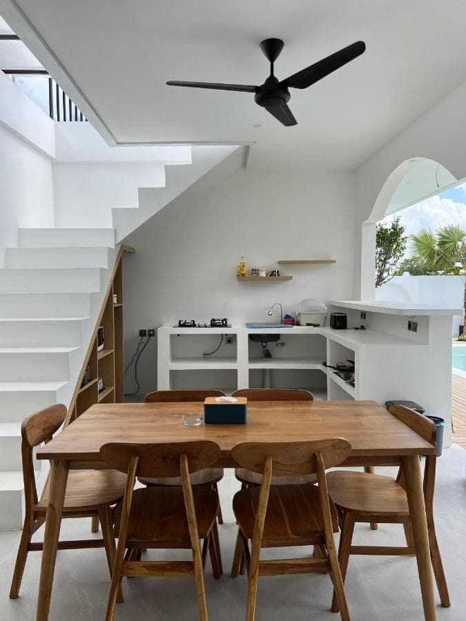 a dining room with a wooden table and chairs at Casadela Canggu in Canggu