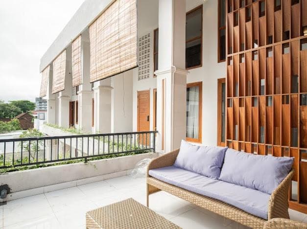 a couch sitting on the balcony of a building at Aspen bali nusa dua in Nusa Dua