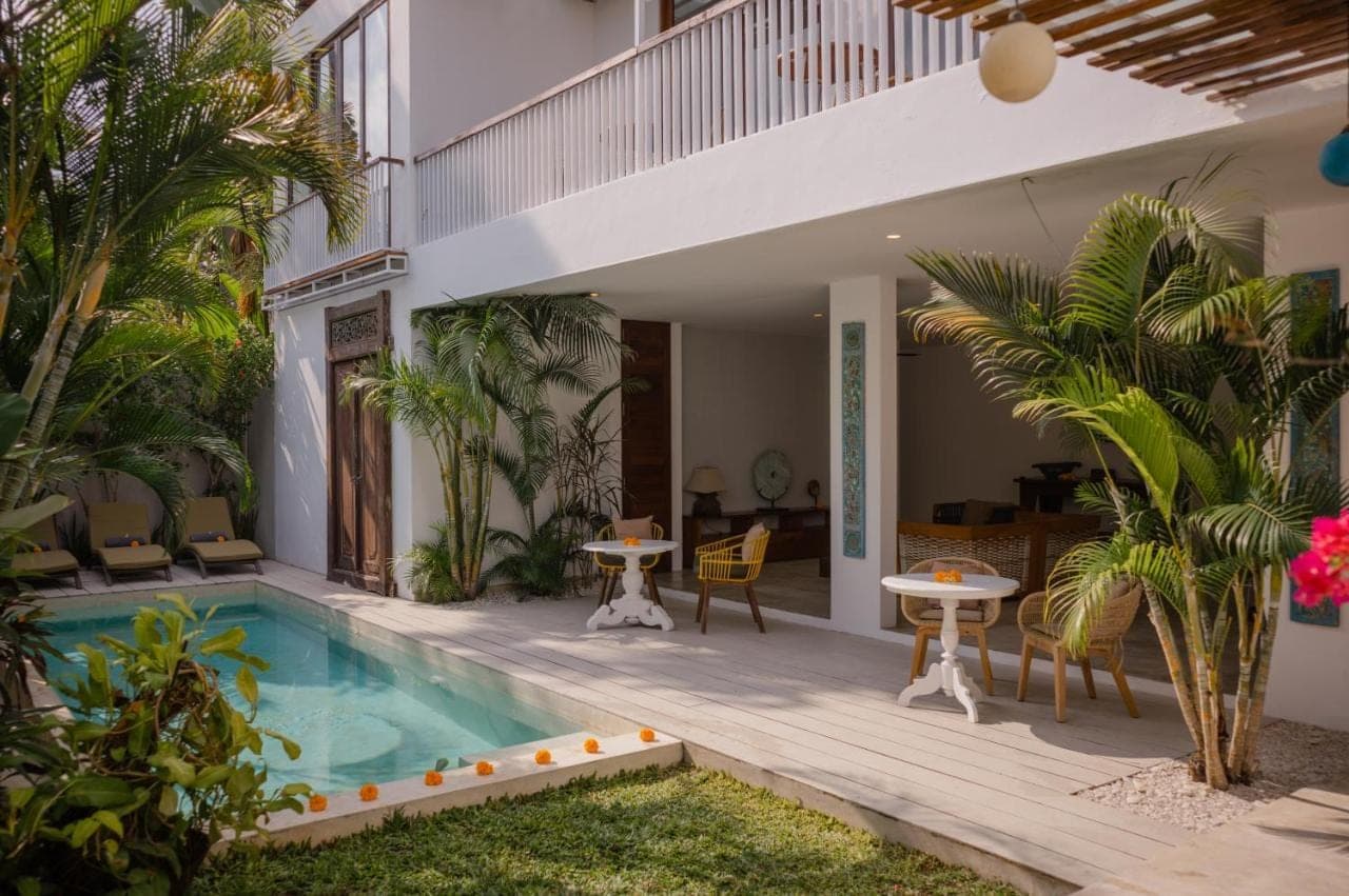 a house with a swimming pool and a patio at The Bed by The Sea in Canggu