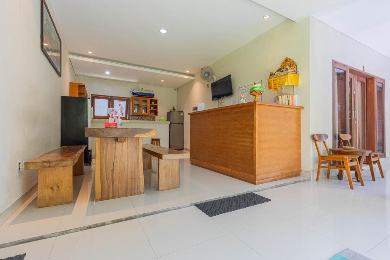 a kitchen with wooden tables and chairs in a room at Komala Homestay in Canggu