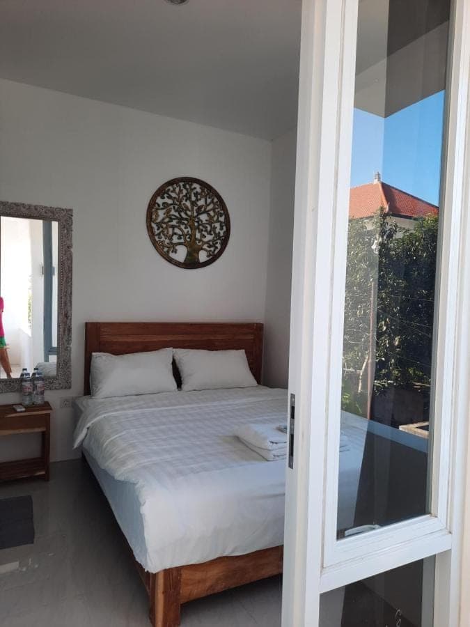 a bedroom with a bed and a window at Roemah Mawar in Sanur