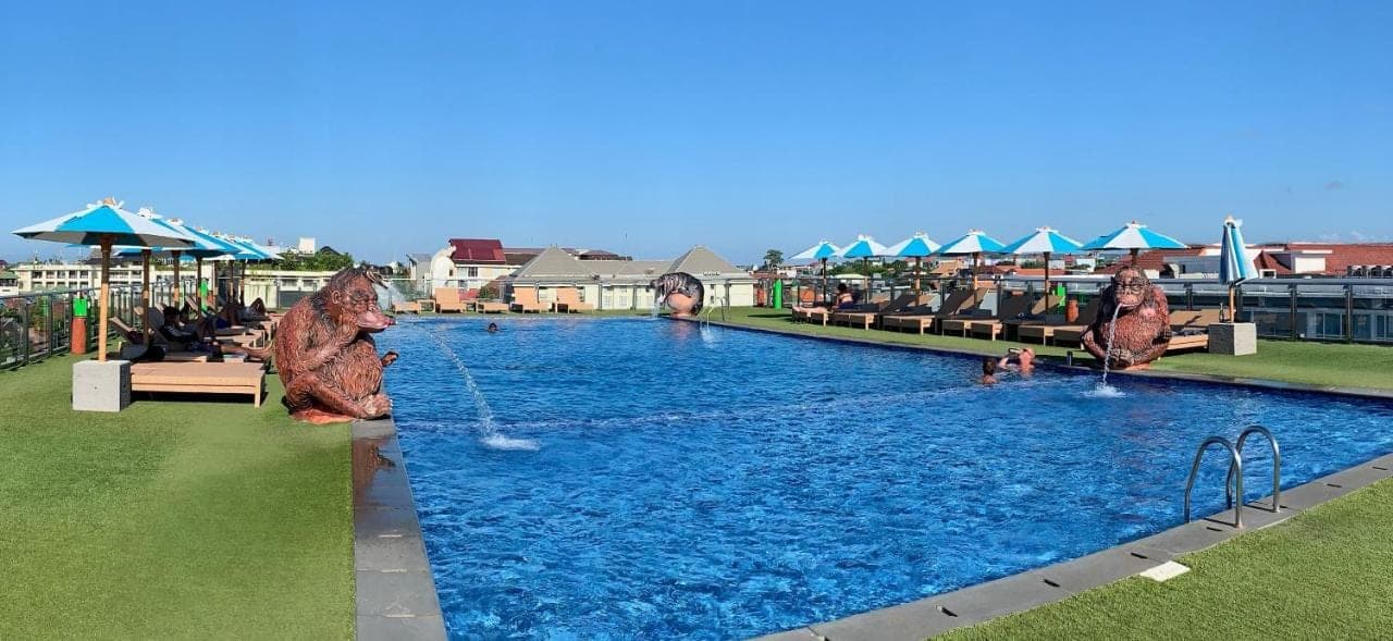 a pool at a resort with people playing in it at Sulis Beach Hotel &amp; Spa in Kuta