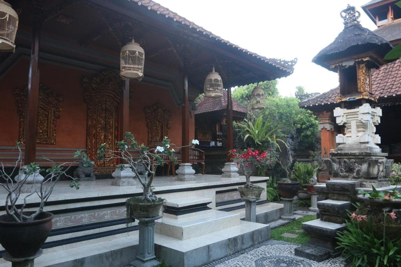 a building with stairs and potted plants in front of it at Sekar Waru Homestay in Sanur