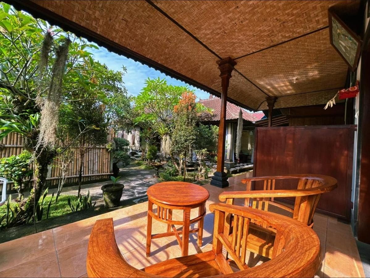 a patio with a table and chairs on a porch at Milla's Homestay in Sidemen