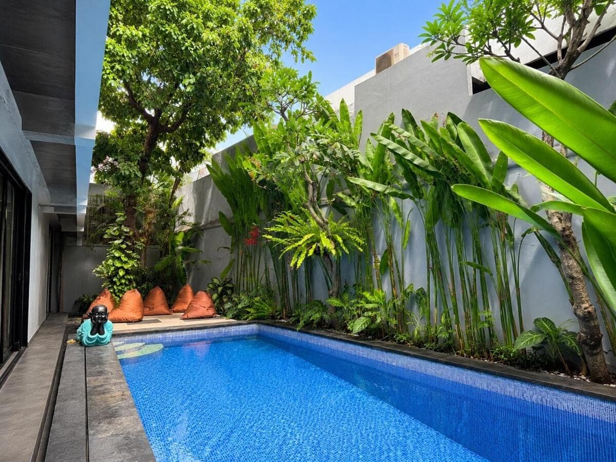 a pool in the middle of a building with plants at Balissimo - 1BR Pool View Studio Seminyak in Seminyak
