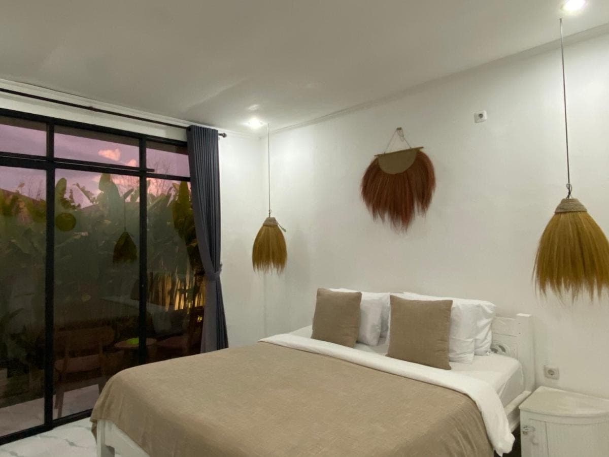 a bedroom with a bed and a window at Yuli Homestay in Uluwatu