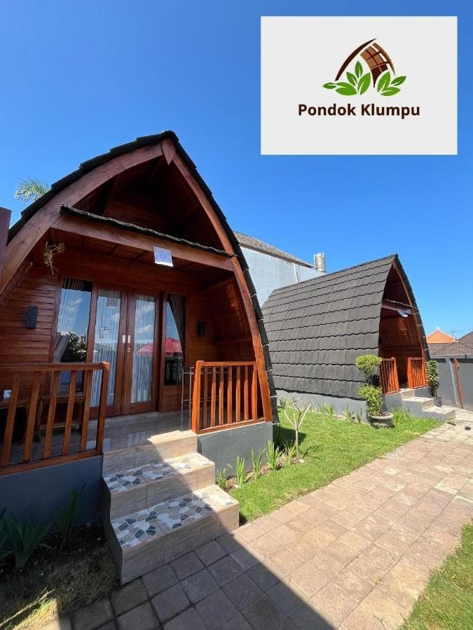 a small wooden house with a staircase in front of it at Pondok Klumpu in Nusa Dua
