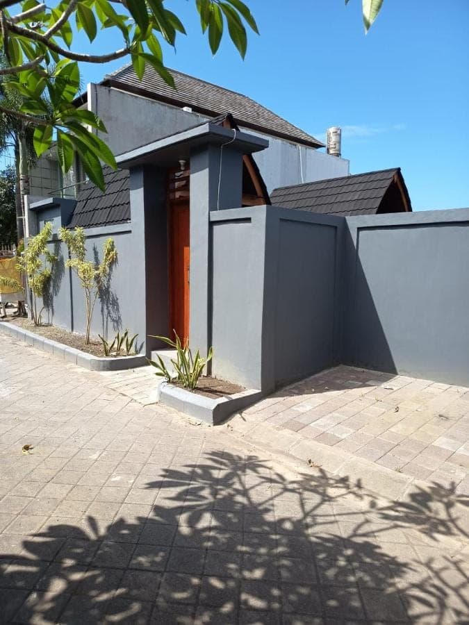 a white house with a fence in front of it at Pondok Klumpu in Nusa Dua