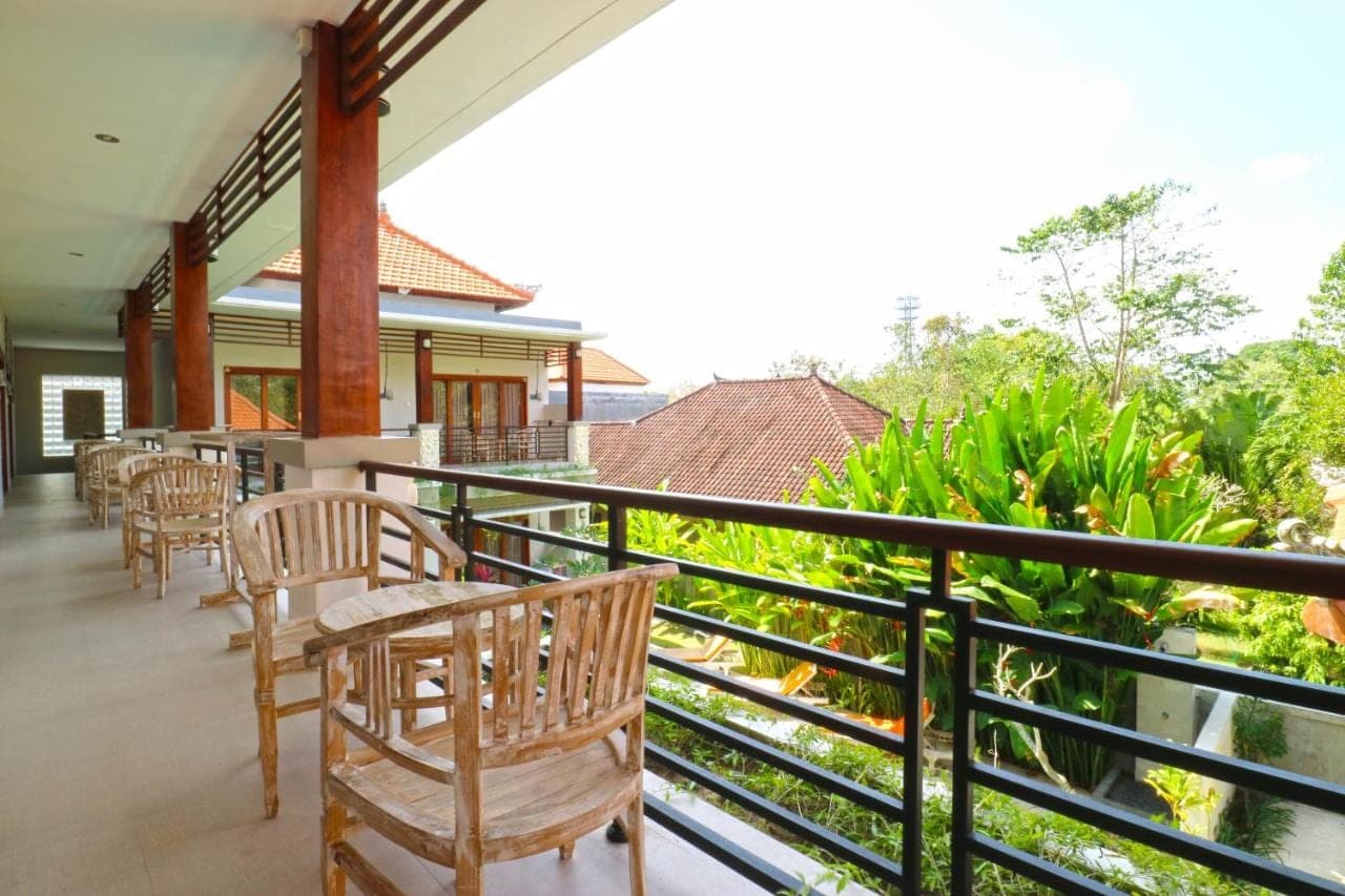 a balcony of a house with chairs and tables at Avisara Nusa Dua in Nusa Dua