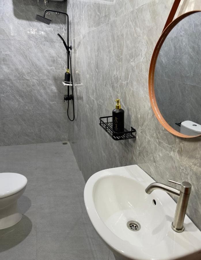 a bathroom with a sink and a mirror and a toilet at D'Kusuma House Sidemen in Sidemen