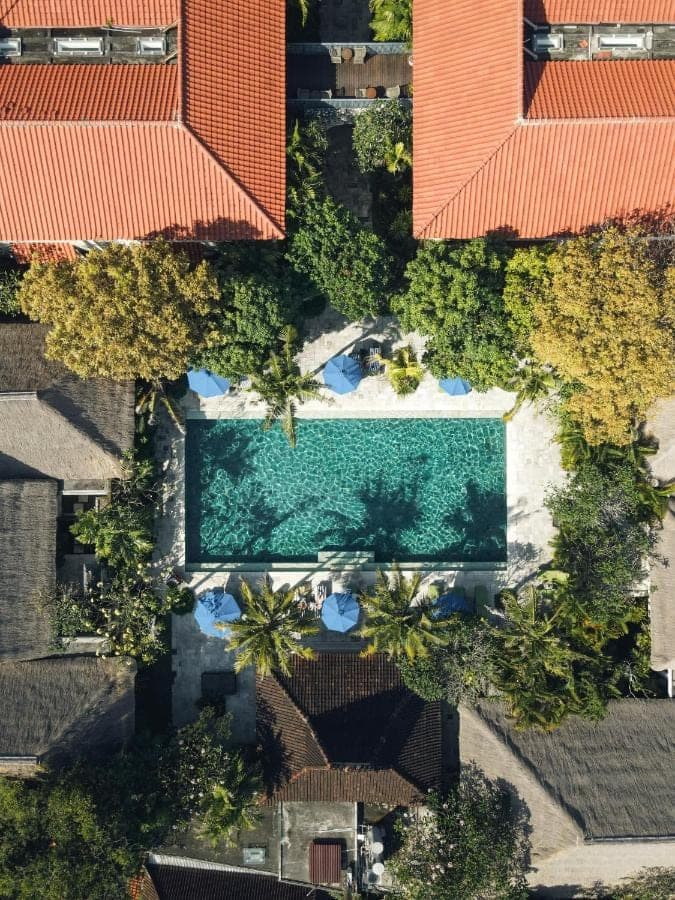 an overhead view of a swimming pool with orange roofs at Sudamala Resort, Sanur, Bali in Sanur