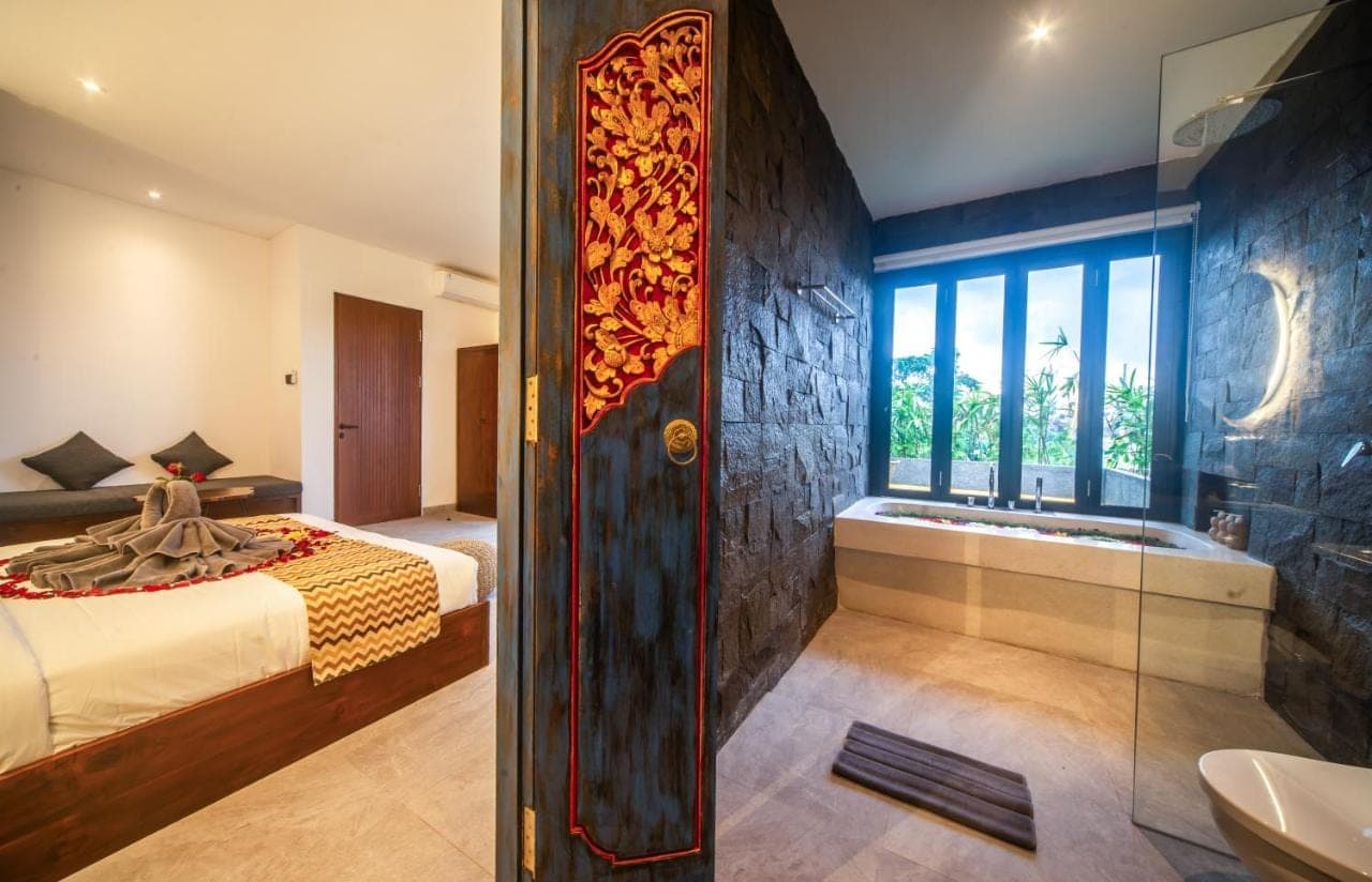 a bathroom with a bed and a bath tub next to a window at 3Bedroom - 703 - Private Pool Villa Sanur in Sanur