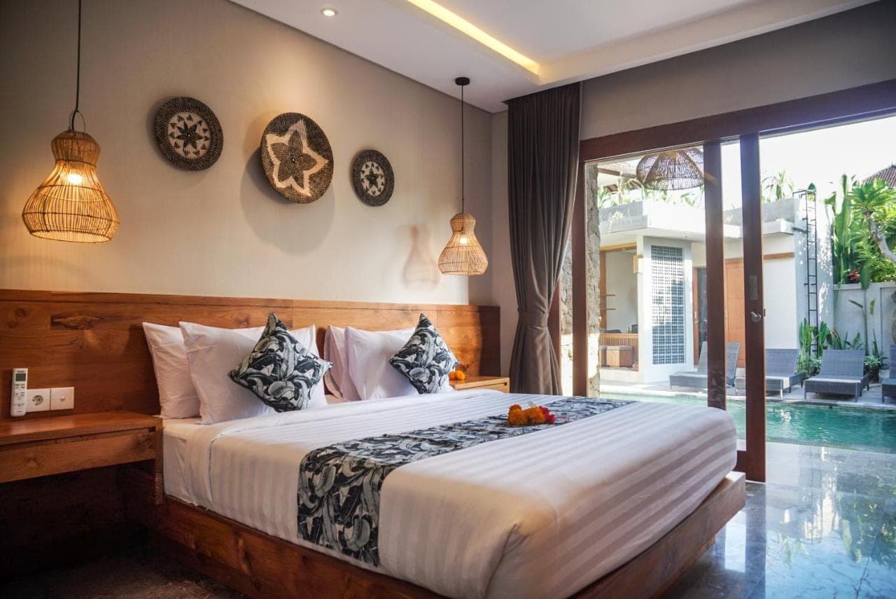a bedroom with a large bed and a pool at Bisma Terrace Suite Ubud in Ubud