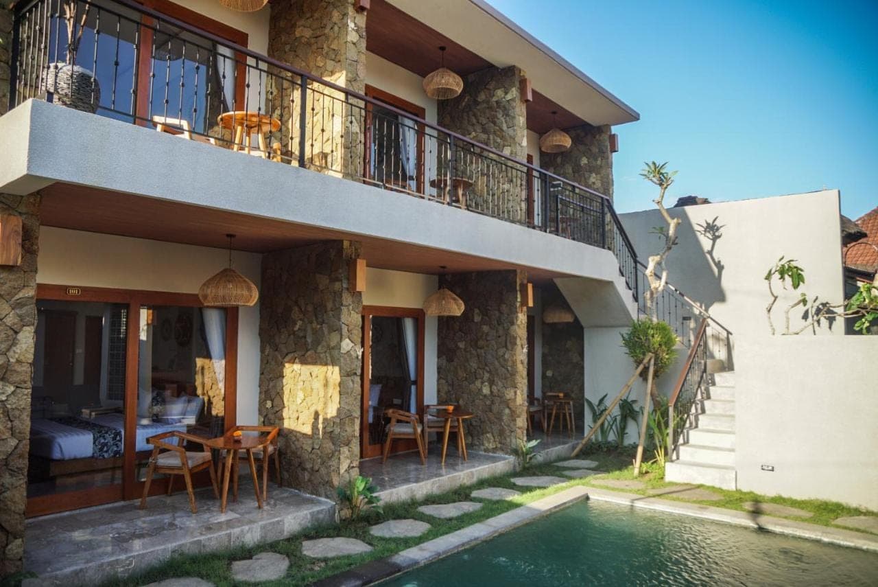 a house with a swimming pool in front of it at Bisma Terrace Suite Ubud in Ubud
