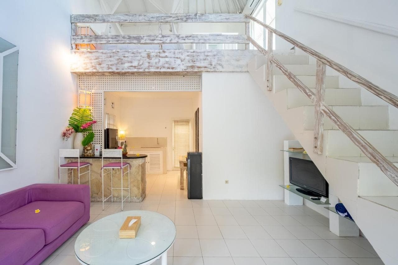 a living room with a purple couch and a table at Villa Margaretta in Seminyak