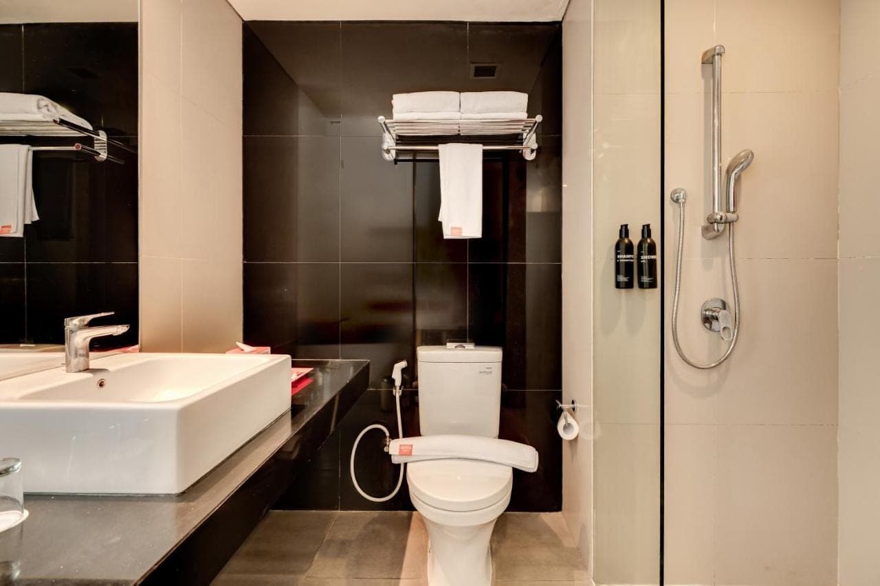 a bathroom with a toilet and a sink and a shower at HARRIS Hotel Seminyak in Seminyak