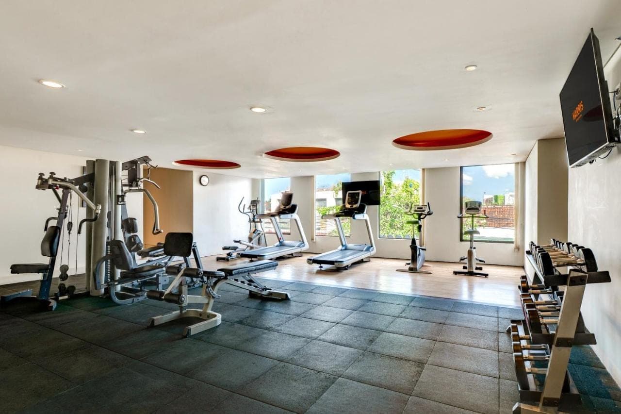 a gym with treadmills and ellipticals in a room at HARRIS Hotel Seminyak in Seminyak