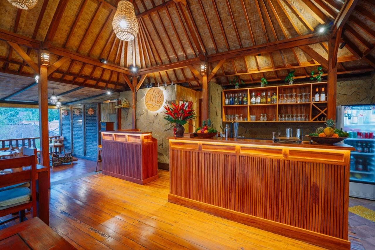 a bar in a restaurant with wooden floors and ceilings at Villa Karma Loka in Sidemen