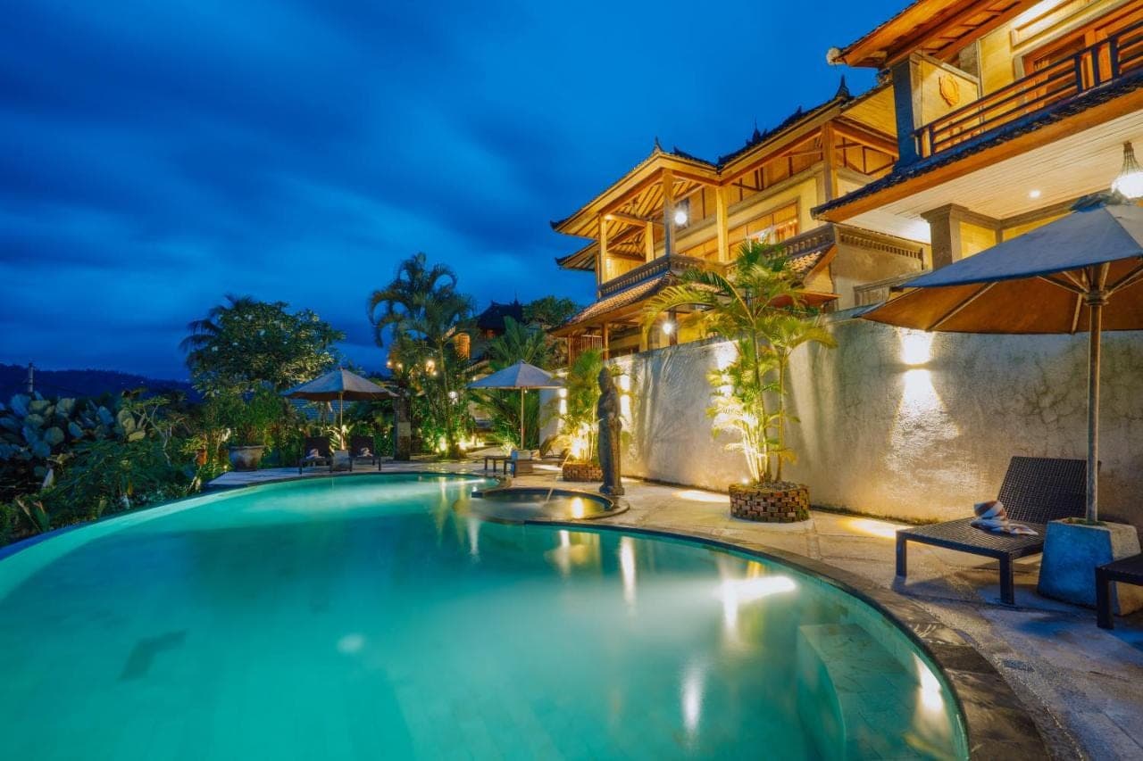 a swimming pool in front of a house at night at Villa Karma Loka in Sidemen