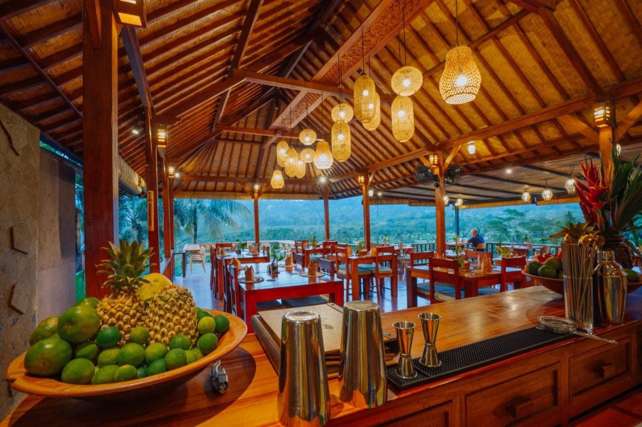 a restaurant with a bowl of fruit on a table at Villa Karma Loka in Sidemen