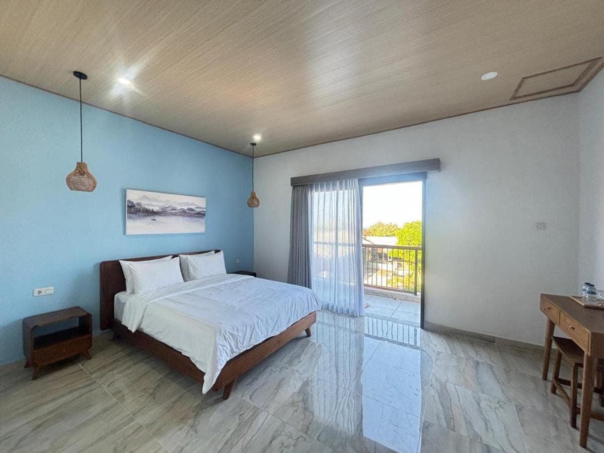 a bedroom with a large bed and a balcony at Sora House in Nusa Dua