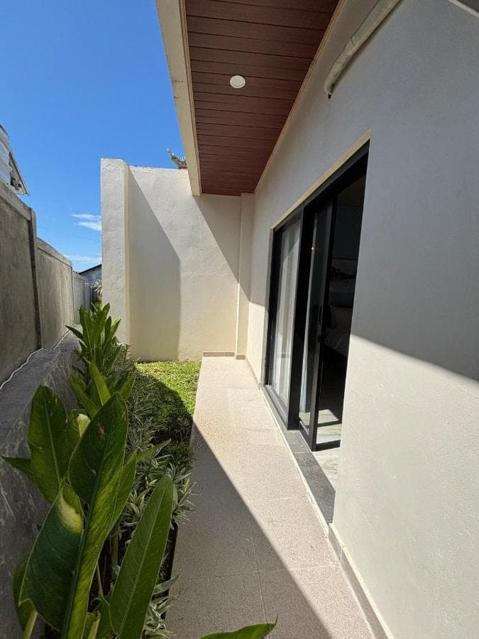 a house with a walkway next to a building at Sora House in Nusa Dua