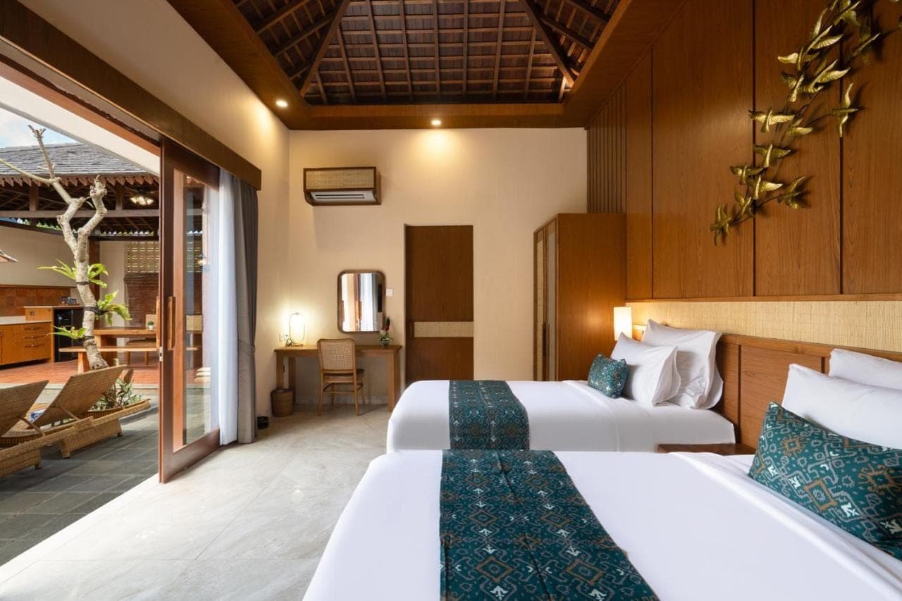 a hotel room with two beds and a living room at Sarva Ubud Villas &amp; Spa in Ubud