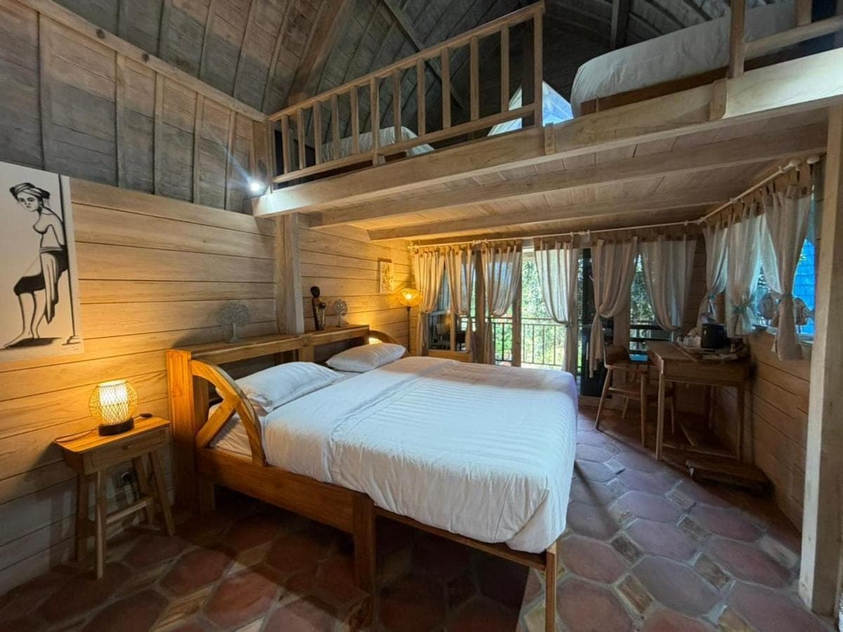 a bedroom with a bed in a wooden room at Nanun Paradise Uluwatu in Uluwatu
