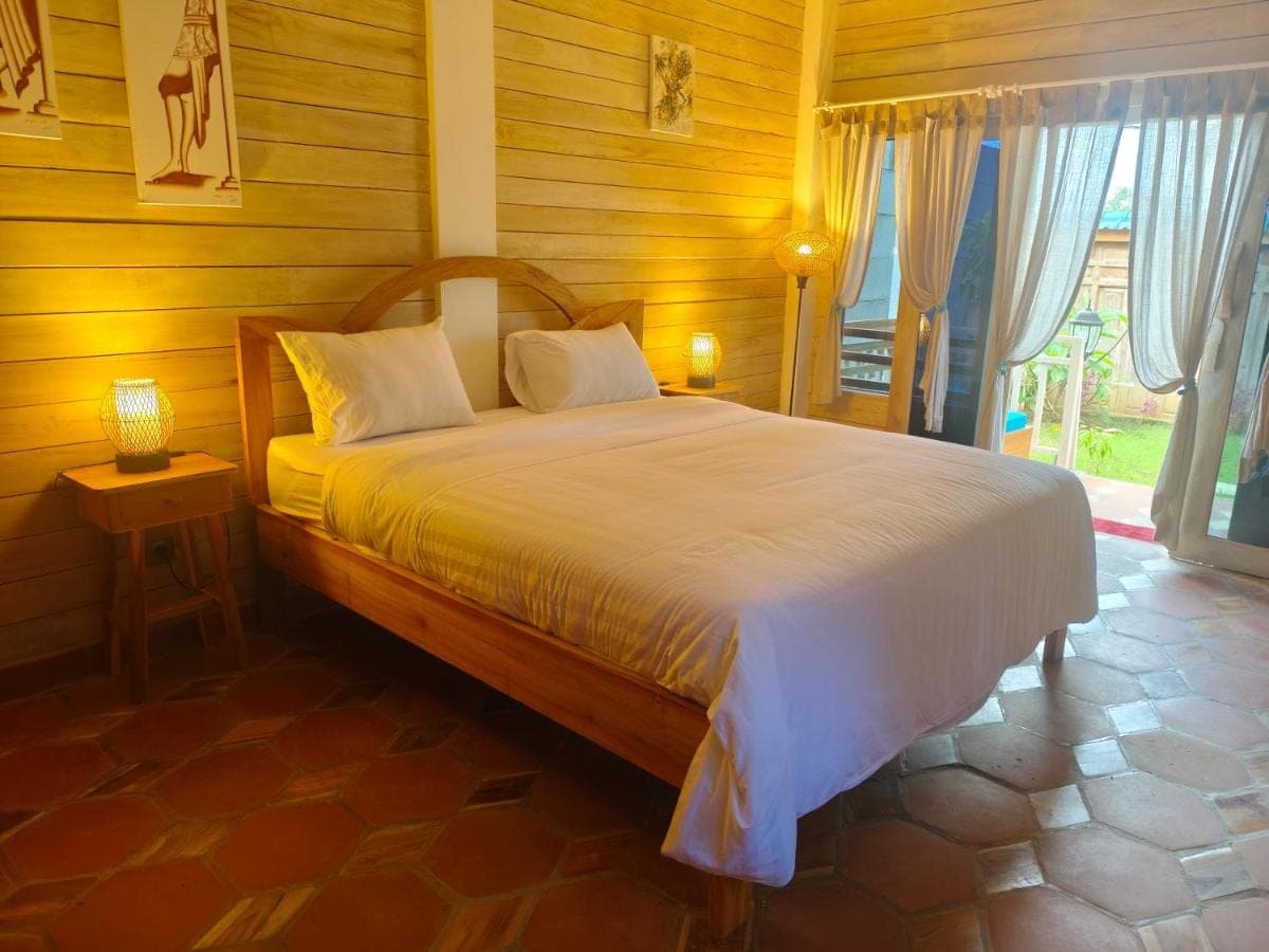 a bedroom with a bed in a room with wooden walls at Nanun Paradise Uluwatu in Uluwatu