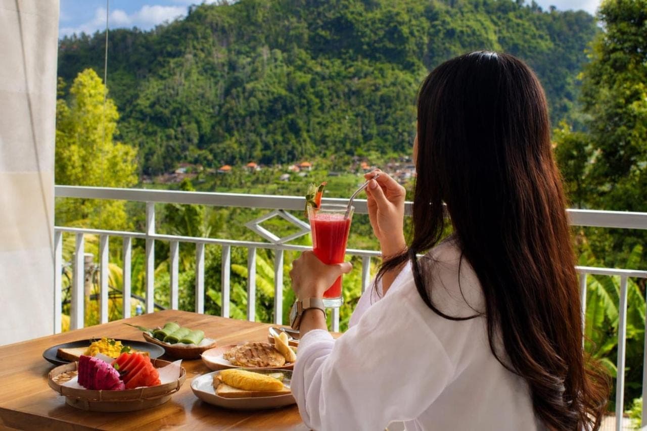 a woman sitting at a table with a plate of food at SARALA sidemen in Sidemen