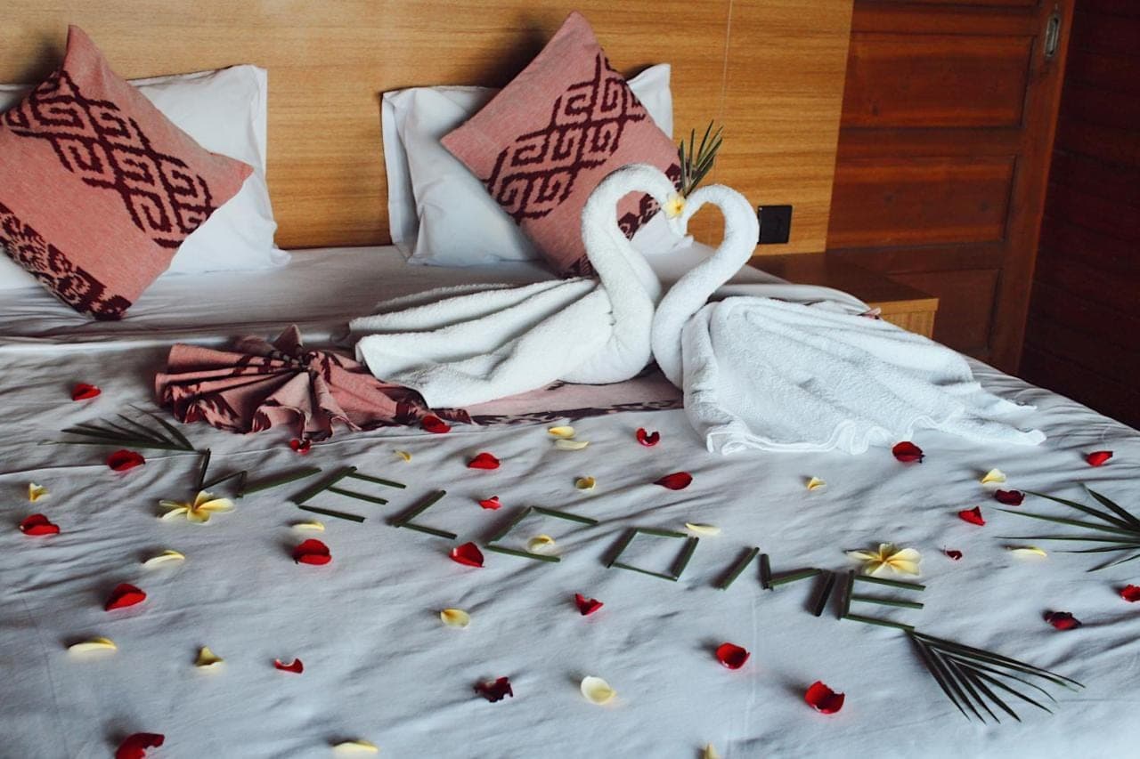 two swans sitting on top of a bed with christmas decorations at STHANATAPA HILL's in Sidemen