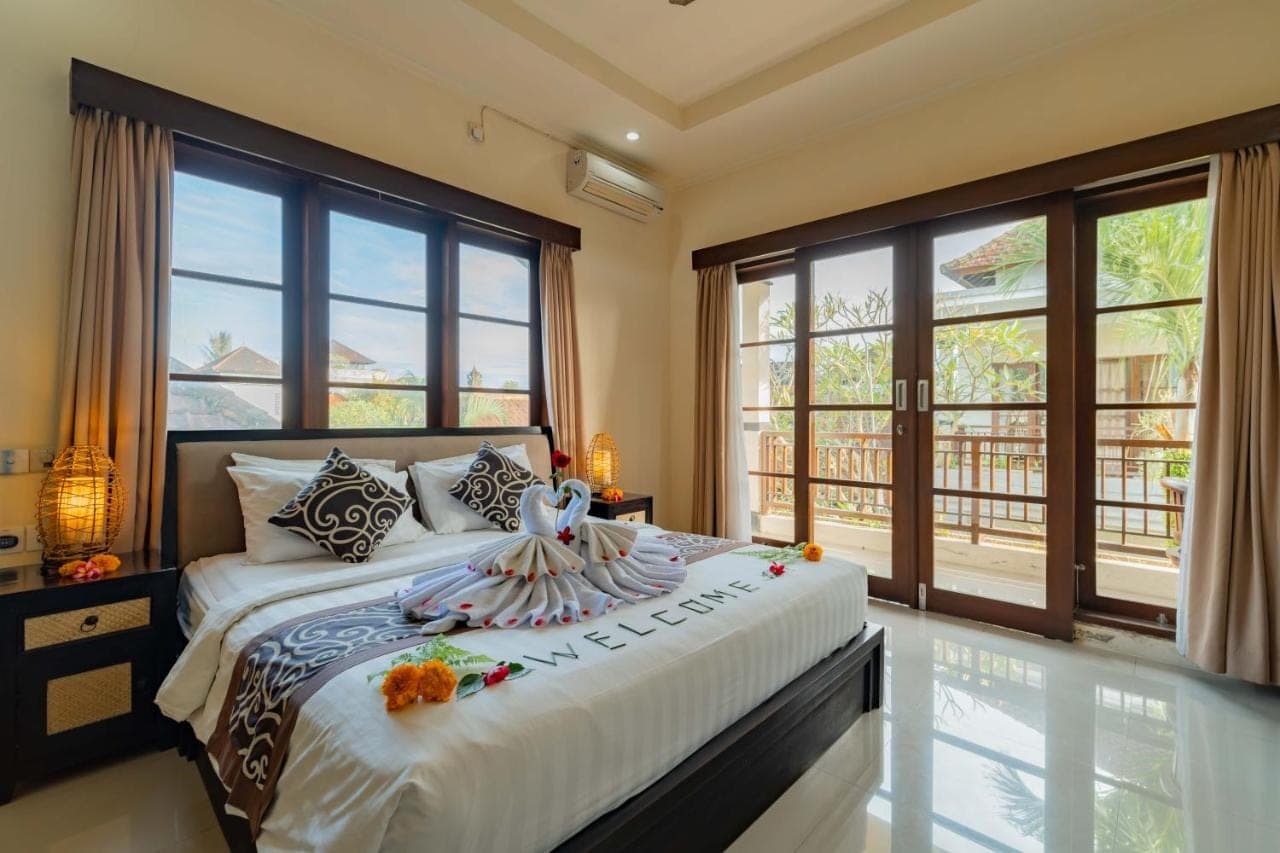 a bedroom with a large bed with flowers on it at Umah Gatra Ubud in Ubud