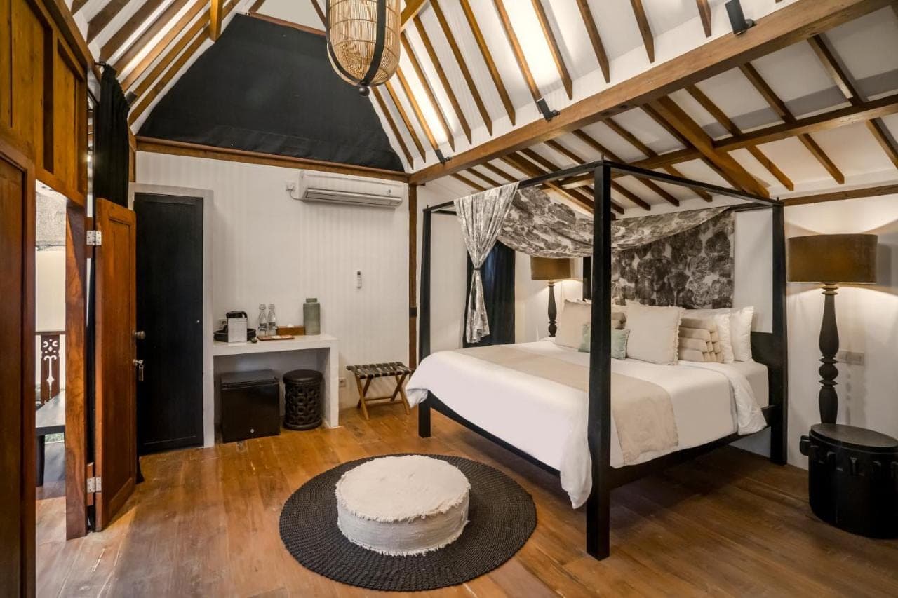 a bedroom with a canopy bed and a desk at Bloom Resort Bali by BaliSuperHost in Canggu
