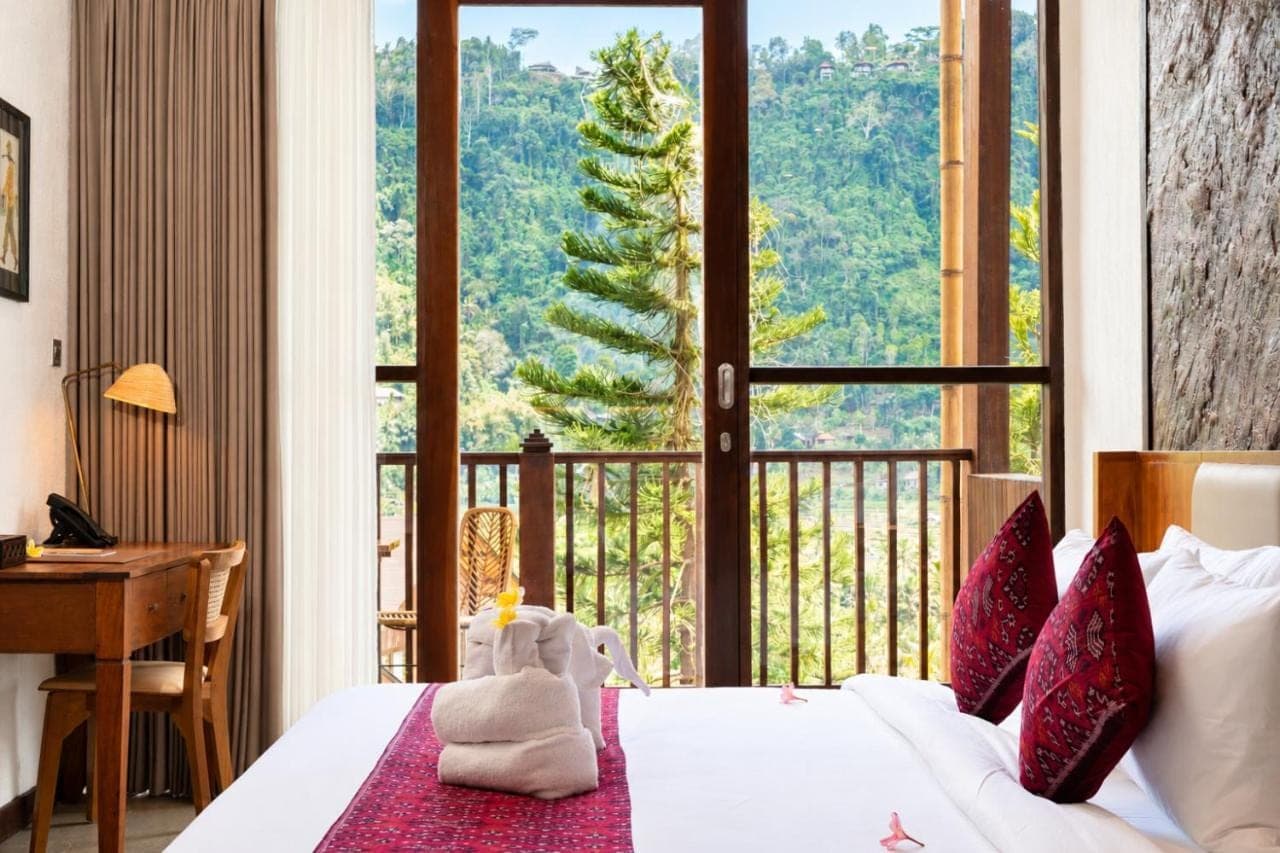 a bedroom with a bed and a large window at Kropak Sidemen in Sidemen
